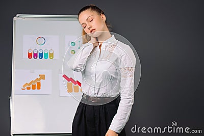 The businesswoman during the conference feeling bad. Pain and fatigue. Gray background Stock Photo