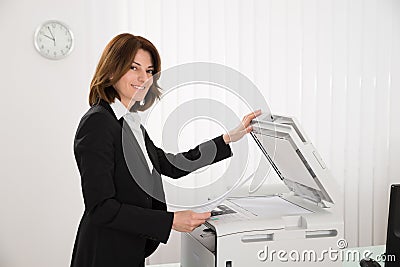 Businesswoman Copying Paper On Photocopy Machine Stock Photo
