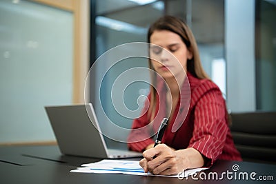 A businesswoman in a crimson gown Prepare to present work and new projects Stock Photo