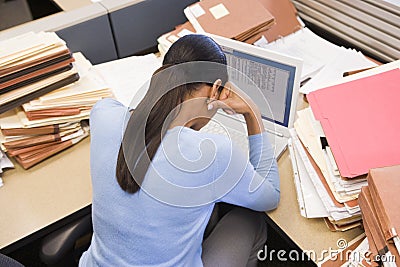 Businesswoman in cubicle with laptop Stock Photo