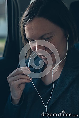 Businesswoman dictating into smartphone earphones microphone Stock Photo