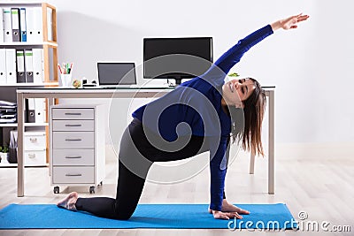 Businesswoman Doing Workout In Office Stock Photo