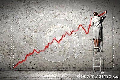 Businesswoman drawing diagrams on wall Stock Photo