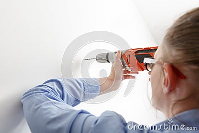 Businesswoman drilling with electric power driller Stock Photo