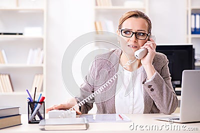 The businesswoman employee talking on the office phone Stock Photo