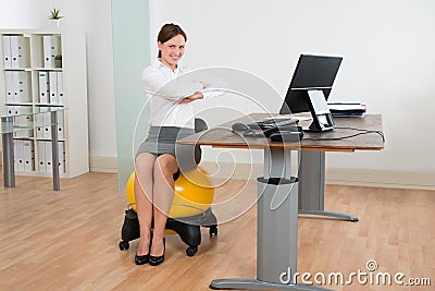 Businesswoman Exercising On Pilates Ball Stock Photo