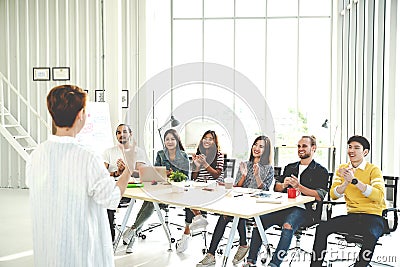 Businesswoman explain ideas to group of creative diverse team at modern office. Rear view of manager gesturing hand standing again Stock Photo