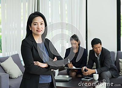 Businesswoman female leader standing and cross arm with team in Stock Photo