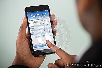 Businesswoman Filling Online Survey On Mobile Phone Stock Photo