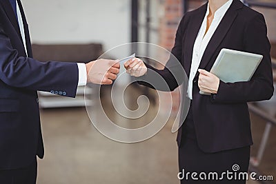 Businesswoman giving business card to client in office Stock Photo