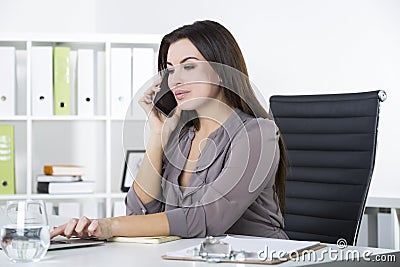 Businesswoman in gray on her phone, typing Stock Photo