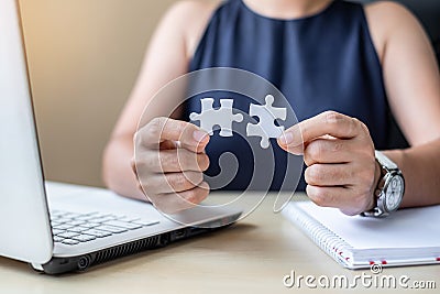 Businesswoman Hand connecting couple puzzle piece in office. Business solutions, mission, successful, goals and strategy concepts Stock Photo