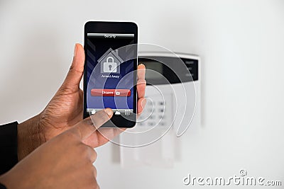 Businesswoman Hand Disarming Security System Stock Photo