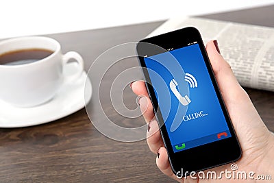 Businesswoman hand holding a phone with ringing phone receiver o Stock Photo