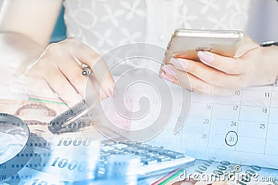 Businesswoman hand holding smart phone, money and calenda Stock Photo