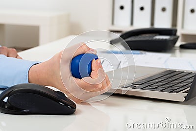 Businesswoman hand squeezing stress ball Stock Photo