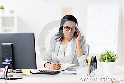 Businesswoman with headset and notebook at office Stock Photo
