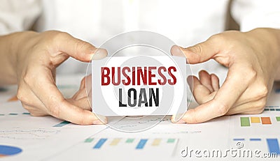 Businesswoman holding a card with text BUSINESS LOAN Stock Photo