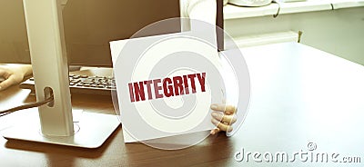 Businesswoman holding card with text INTEGRITY in the hands Stock Photo