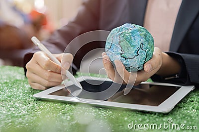 Businesswoman holding an Earth model and use tablet for analyze Environmental technology and approaching global sustainable ESG Stock Photo