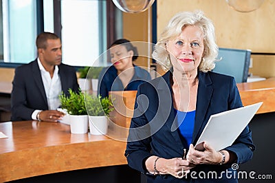 Businesswoman Holding File At Reception Counter Stock Photo