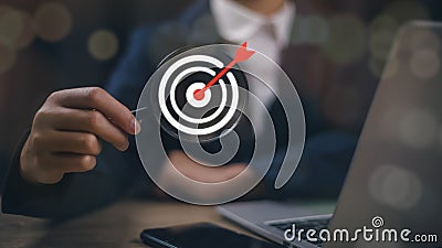 Businesswoman holding magnifier glass with white dartboard for setup and focus in objective target goal concept Stock Photo