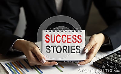 businesswoman holding a notebppk with text SUCCESS STORIES business Stock Photo