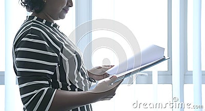 Businesswoman holding and turning pages of a file in hand Stock Photo