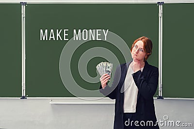 Businesswoman holds us dollars at the school board with the inscription Stock Photo