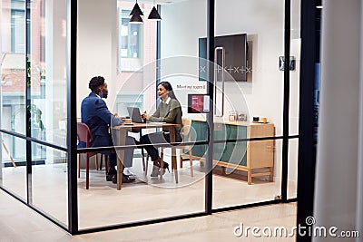 Businesswoman Interviewing Male Job Candidate In Meeting Room Stock Photo