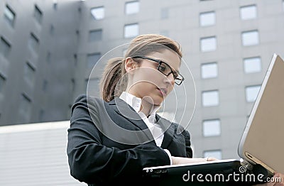 Businesswoman with laptop computer on the city Stock Photo