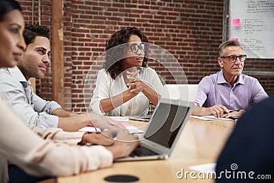 Businesswoman Leading Office Meeting Of Colleagues Sitting Around Table Stock Photo