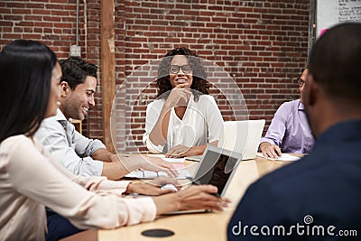 Businesswoman Leading Office Meeting Of Colleagues Sitting Around Table Stock Photo