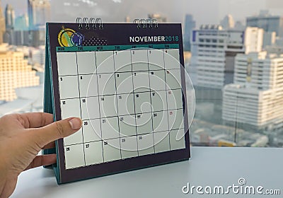 Businesswoman left hand holds November 2018 calendar for appointment reminder Stock Photo