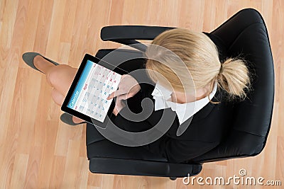 Businesswoman Looking At Calendar On Digital Tablet Stock Photo