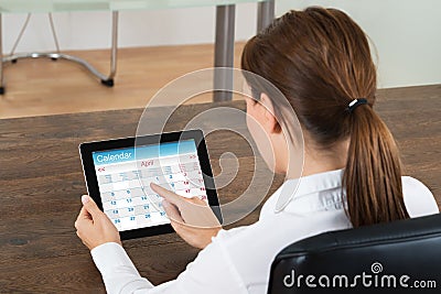 Businesswoman Looking At Calendar On Digital Tablet Stock Photo