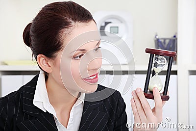 Businesswoman looking at hourglass. Stock Photo