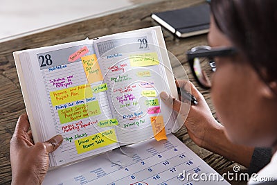 Businesswoman Looking At List Of Business Work In Diary Stock Photo