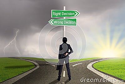 Businesswoman looking at sign of right vs wrong decision Stock Photo