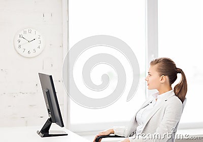 Businesswoman looking at wall clock in office Stock Photo