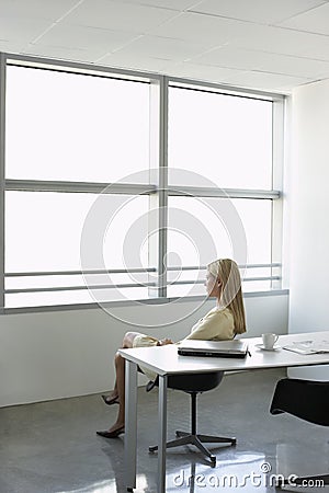 Businesswoman Looking Through Window In Office Stock Photo