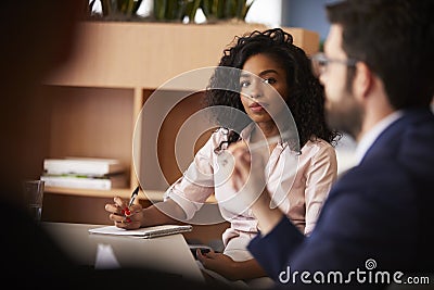 Businesswoman Making Notes Sitting At Table Meeting With Colleagues In Modern Office Stock Photo