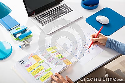 Businesswoman Marking Schedule On Calendar Stock Photo