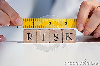 Businesswoman Measuring Risk Blocks With Measuring Tape Stock Photo