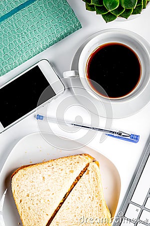Businesswoman morning with coffee, sandwich, mobile on white table background top view Editorial Stock Photo