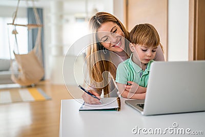 Businesswoman mother woman with a toddler working at the computer at home Stock Photo