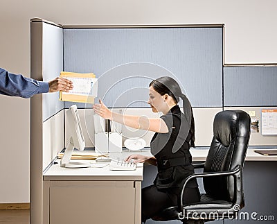 Businesswoman multi-tasking at desk in cubicle Stock Photo