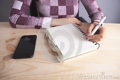Businesswoman notebook pen smartphone on wooden background Stock Photo