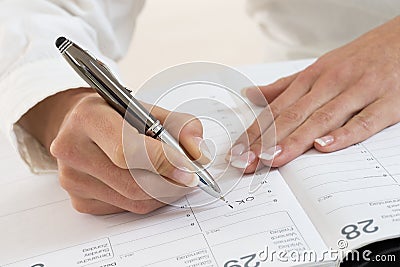 Businesswoman in office noting an appointment Stock Photo