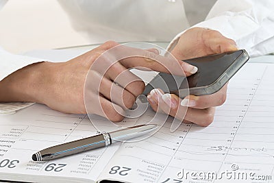 Businesswoman in office noting an appointment Stock Photo